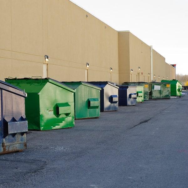 roll-off commercial waste container being delivered to a job site